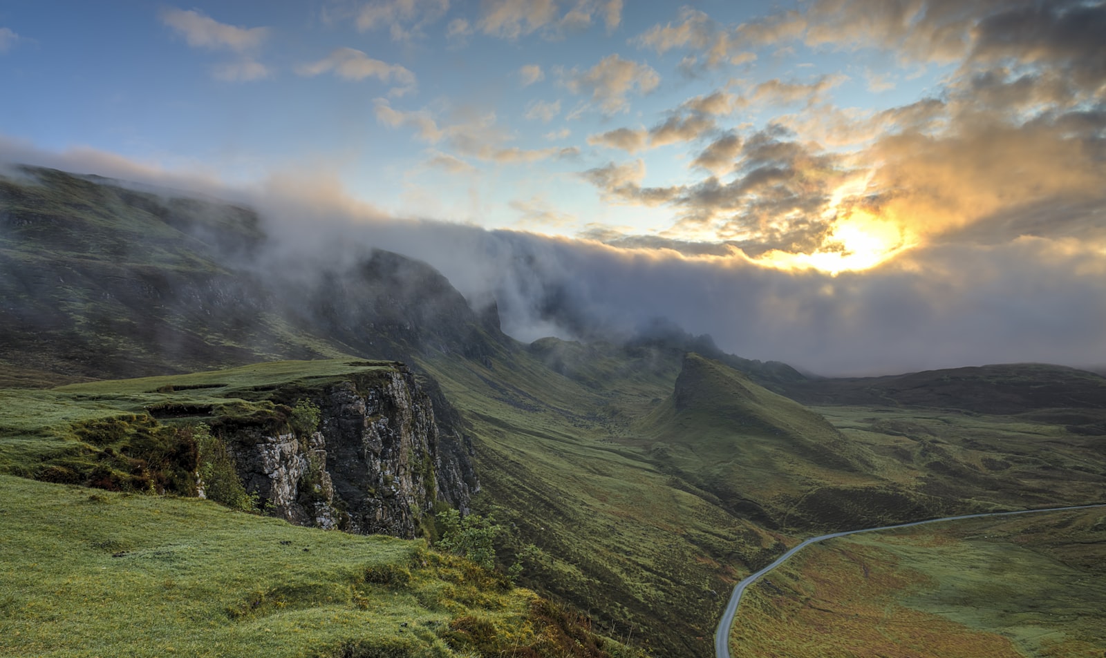 A peaceful foggy valley with rolling green hills at sunrise
